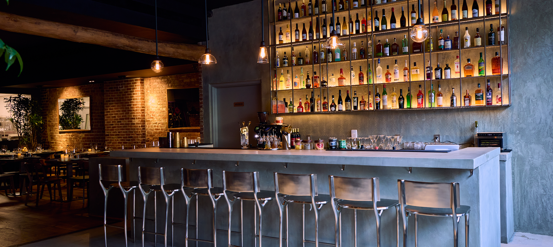 Modern bar with bottles and stools.